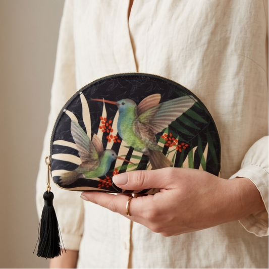 Person holding a round clutch with bird design and tassel